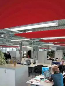 Großraumbüros profitieren von Akustik-Konzepten Deckensegel mit indirekter und direkter Beleuchtung